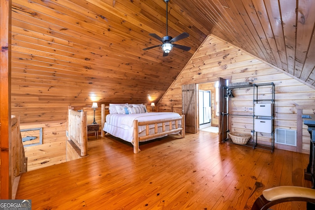 unfurnished bedroom featuring lofted ceiling, wooden ceiling, wooden walls, visible vents, and hardwood / wood-style floors