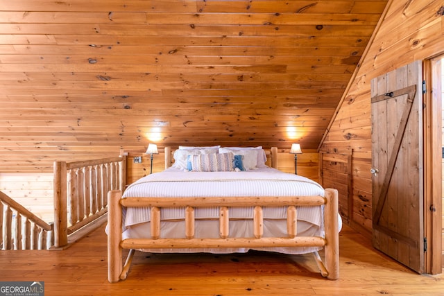 bedroom with wooden ceiling, light wood-style floors, wooden walls, and vaulted ceiling