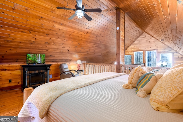 bedroom with a fireplace, wood finished floors, wood ceiling, and wooden walls