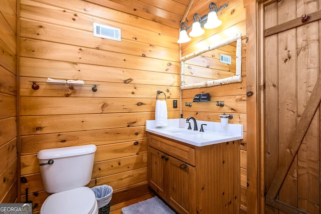 half bathroom with toilet, visible vents, and wooden walls