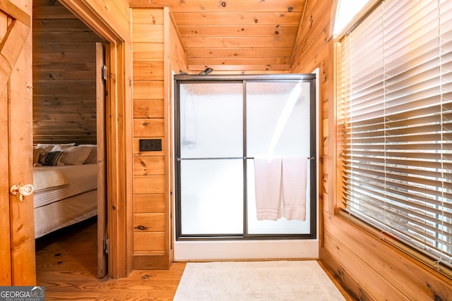 bathroom with connected bathroom, wooden walls, and wood finished floors