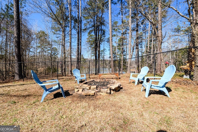 view of yard with an outdoor fire pit and fence