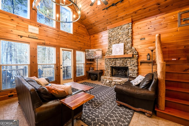 living area featuring a fireplace, ceiling fan, wooden walls, high vaulted ceiling, and wooden ceiling