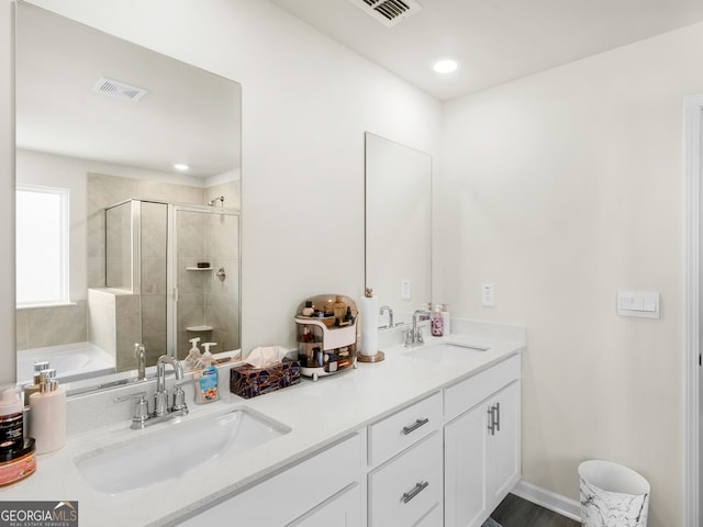 bathroom featuring visible vents, a sink, and a shower stall