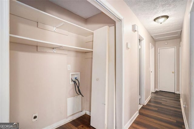 clothes washing area featuring a textured ceiling, laundry area, washer hookup, dark wood-style flooring, and baseboards