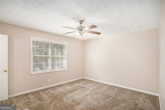 spare room with carpet floors, a ceiling fan, baseboards, and a textured ceiling