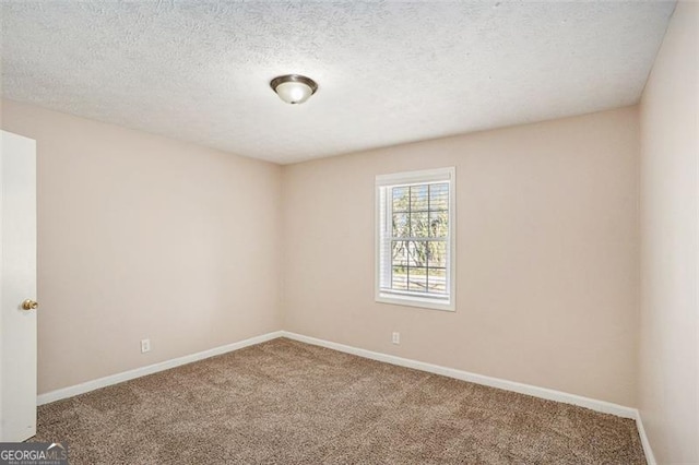 carpeted empty room with a textured ceiling and baseboards