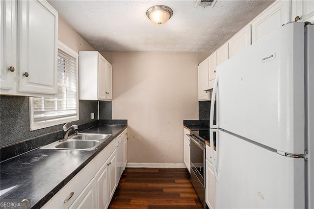 kitchen with electric range, dark wood finished floors, freestanding refrigerator, white cabinetry, and a sink