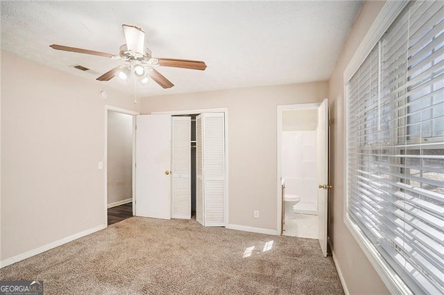 unfurnished bedroom featuring connected bathroom, a ceiling fan, baseboards, a closet, and carpet