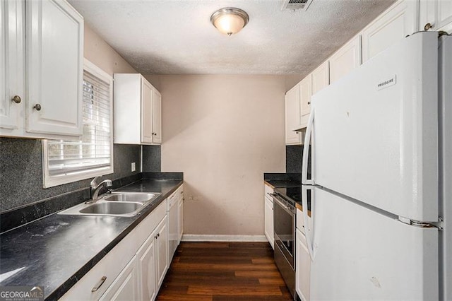 kitchen featuring dark wood-type flooring, a sink, white cabinets, freestanding refrigerator, and stainless steel electric range oven