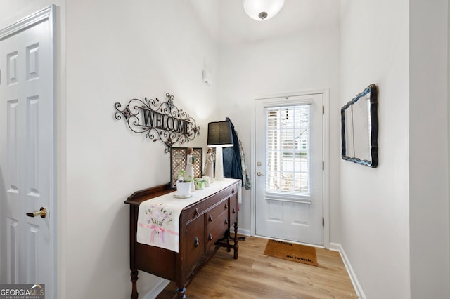 entryway featuring baseboards and light wood-type flooring