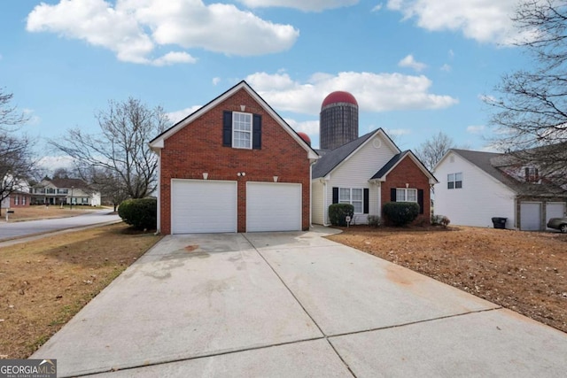 traditional home featuring driveway, a garage, and brick siding