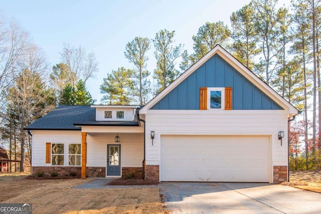 view of front of home with concrete driveway, board and batten siding, and stone siding