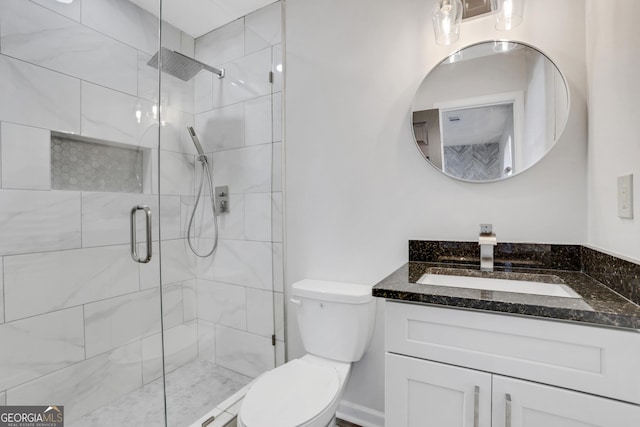 bathroom with vanity, a shower stall, and toilet