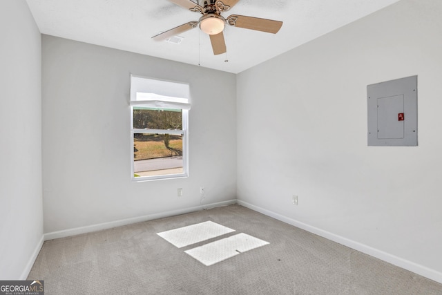 carpeted spare room featuring electric panel, ceiling fan, and baseboards