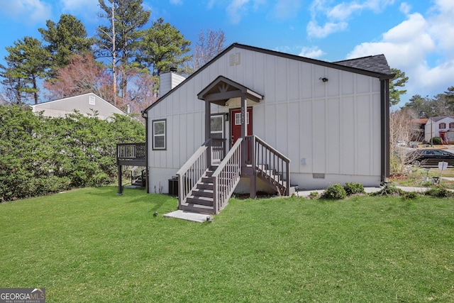 exterior space featuring a chimney, board and batten siding, a front yard, crawl space, and central AC