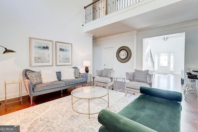 living room with baseboards, a high ceiling, and wood finished floors