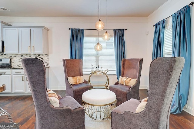 living area with ornamental molding, plenty of natural light, visible vents, and dark wood finished floors