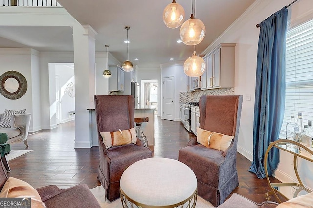 living area with ornate columns, ornamental molding, dark wood finished floors, and baseboards