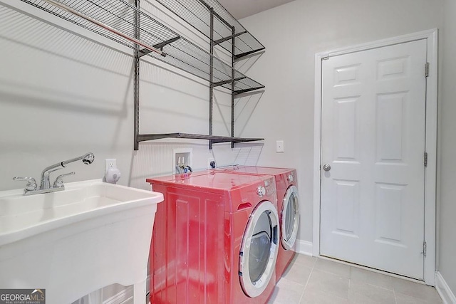 laundry room featuring light tile patterned floors, laundry area, a sink, baseboards, and independent washer and dryer