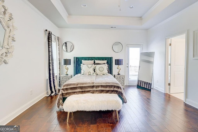 bedroom featuring dark wood-style floors, a raised ceiling, visible vents, and baseboards