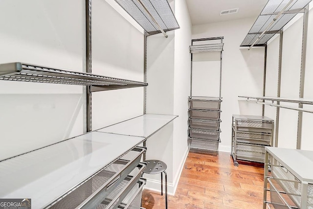 spacious closet featuring visible vents and wood finished floors