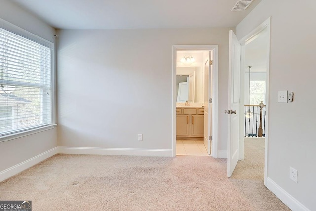 interior space with light carpet, multiple windows, a sink, and visible vents