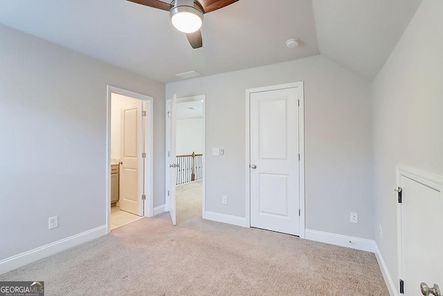 unfurnished bedroom featuring ensuite bathroom, light carpet, a ceiling fan, visible vents, and baseboards