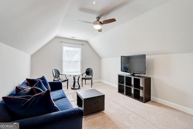 living room featuring lofted ceiling, ceiling fan, baseboards, and light colored carpet