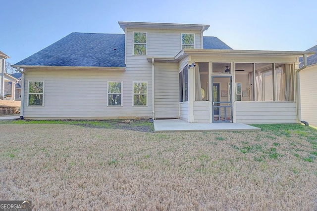 rear view of house featuring a shingled roof, a lawn, and a sunroom