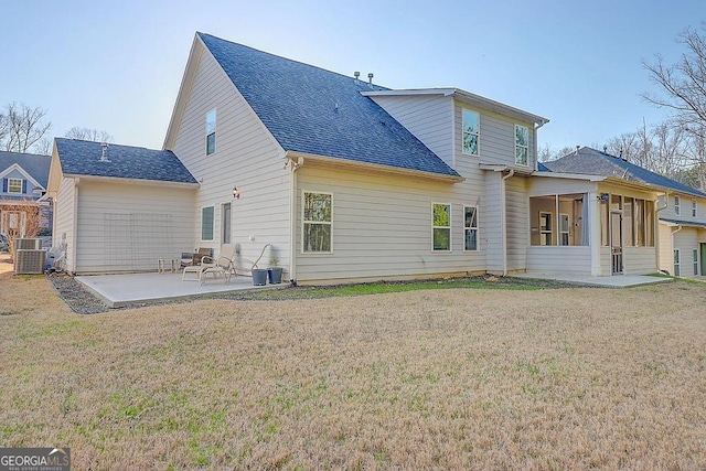 rear view of house with a patio, a yard, roof with shingles, and a sunroom