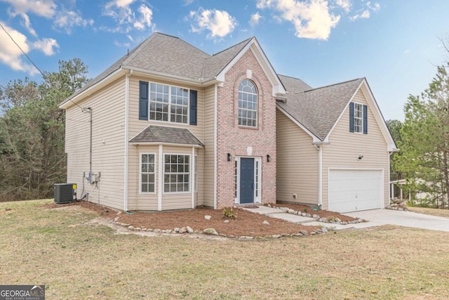 traditional-style house featuring an attached garage, cooling unit, a shingled roof, concrete driveway, and a front lawn