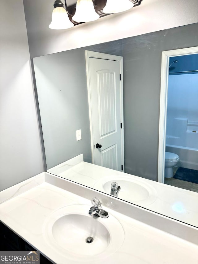 bathroom with shower / bathing tub combination, vanity, and toilet