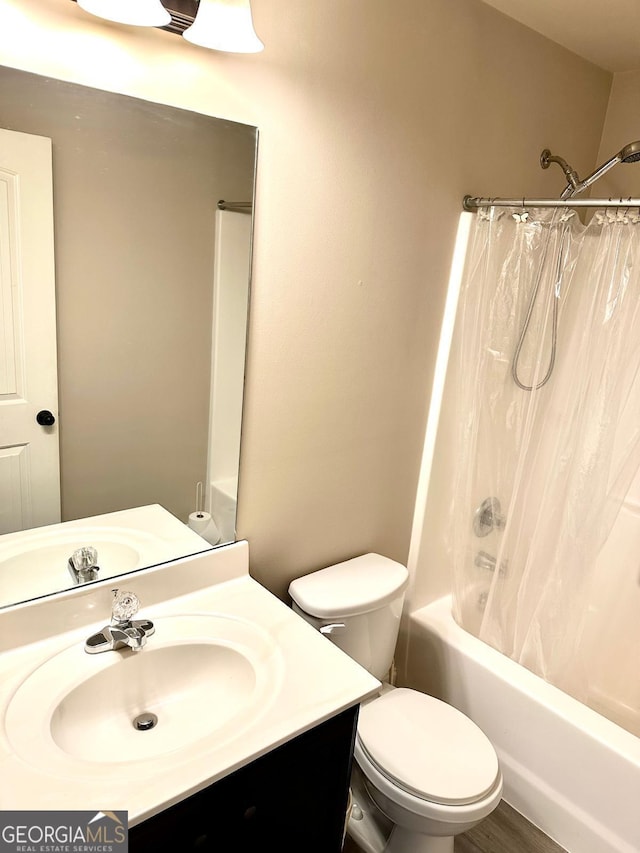 bathroom with toilet, shower / bath combo with shower curtain, and vanity