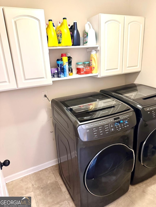 clothes washing area with cabinet space, baseboards, separate washer and dryer, and light tile patterned flooring