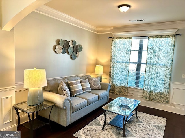 living room with dark wood-style floors, arched walkways, visible vents, and crown molding