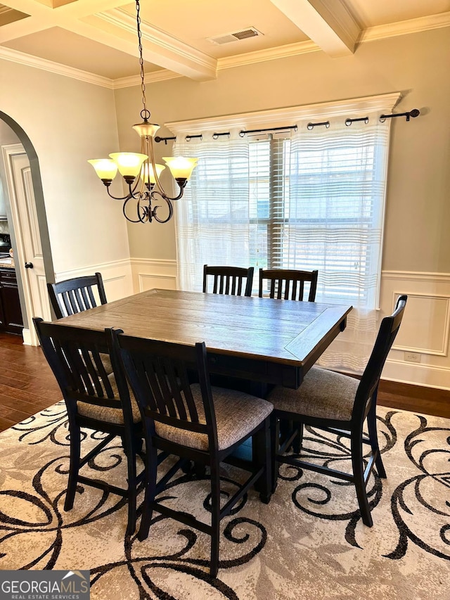 dining area featuring visible vents, arched walkways, beamed ceiling, and wood finished floors