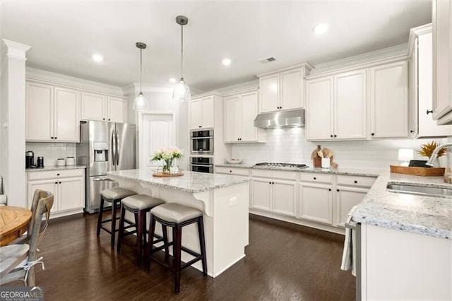 kitchen with visible vents, white cabinets, stainless steel appliances, under cabinet range hood, and a sink