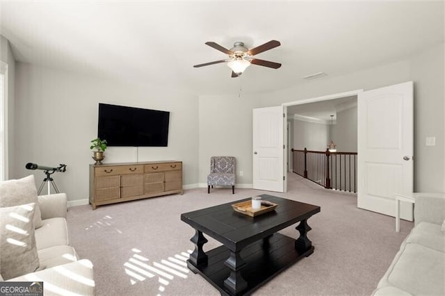 living area with carpet flooring, a ceiling fan, and baseboards