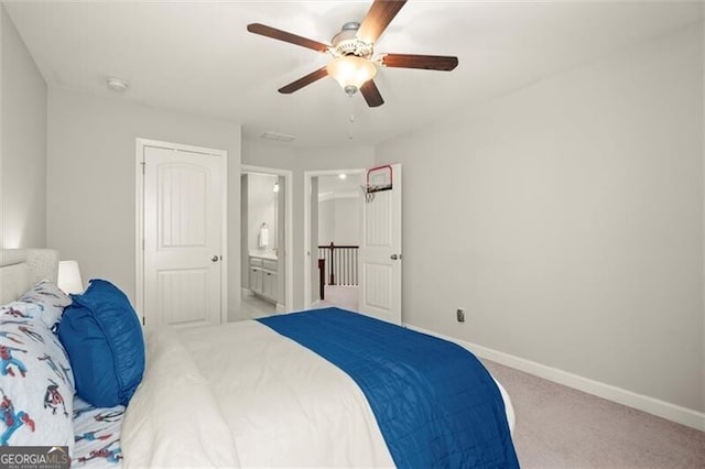 bedroom with carpet floors, connected bathroom, a ceiling fan, and baseboards