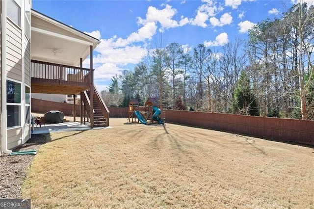 view of play area with stairway, a patio area, fence, and a wooden deck