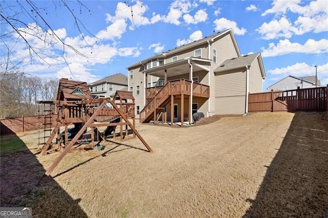 back of house with a deck, a playground, fence, and stairs