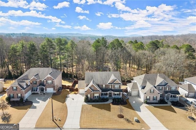 birds eye view of property featuring a wooded view and a residential view