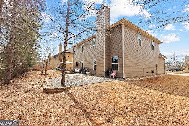 view of property exterior featuring a chimney and a patio area