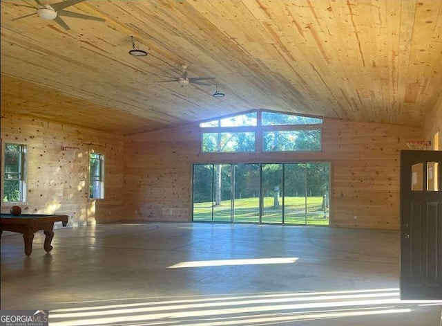 spare room featuring a ceiling fan, lofted ceiling, finished concrete floors, wood walls, and wooden ceiling