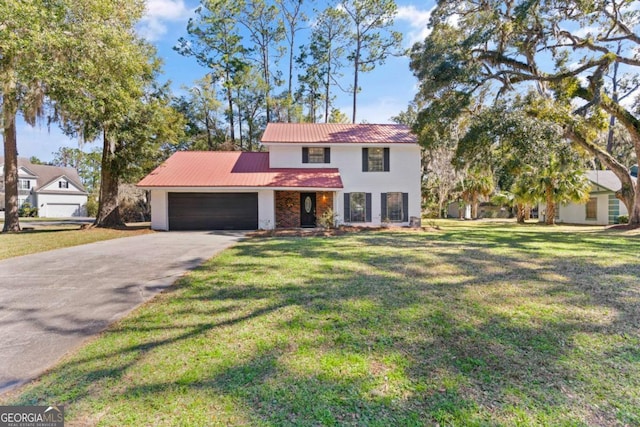 view of front of home featuring an attached garage, driveway, a front lawn, and metal roof