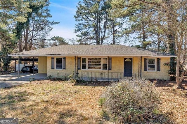 ranch-style home with driveway, an attached carport, and a front yard