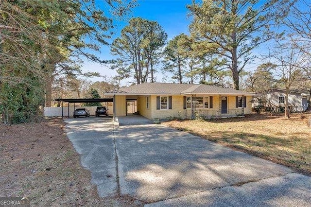 ranch-style house featuring an attached carport and driveway