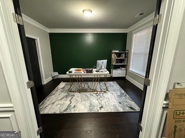 home office with ornamental molding, dark wood-style flooring, visible vents, and baseboards