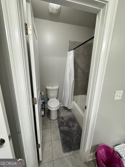 full bath with tile patterned flooring, toilet, and shower / bath combo with shower curtain